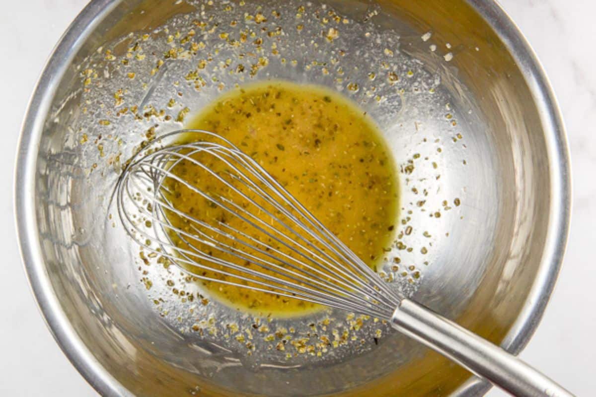 overhead view of the lemon dressing in a bowl with a whisk